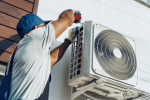 A skilled technician carefully installing an aircon unit in a Serangoon home, ensuring a cool and comfortable space.